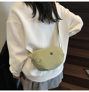 Détail du sac bandoulière en nylon vert menthe avec logo métal et sangle réglable