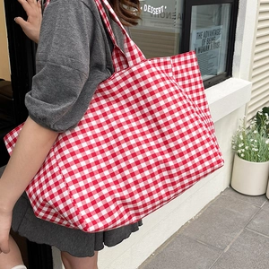 Classic red and white gingham canvas tote bag shown in a stylish outdoor street style view
