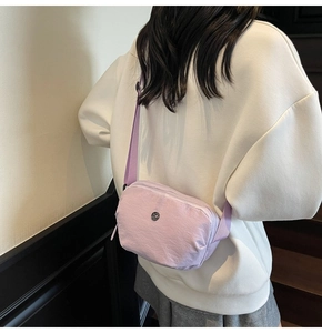 Vue arrière détaillée d'un sac bandoulière en nylon violet clair porté par un mannequin
