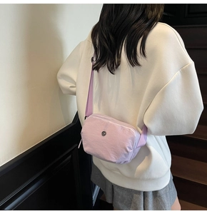 Détail d'un sac bandoulière en nylon lavande avec sangle réglable porté par un mannequin