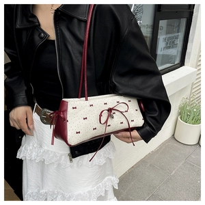 Sac à main à nœuds avec accents bordeaux présenté dans un cadre de rue élégant