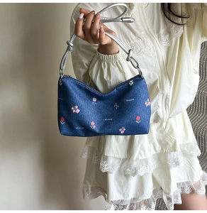 Detail of blue denim floral handbag with Creative Cat print and silver rope strap