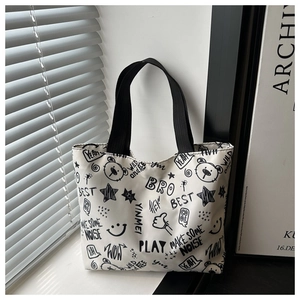 Vue détaillée du grand sac cabas avec des motifs de graffitis noirs sur toile blanche