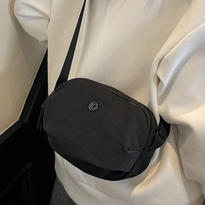 Sac bandoulière décontracté en nylon noir avec sangle réglable et logo en métal rond