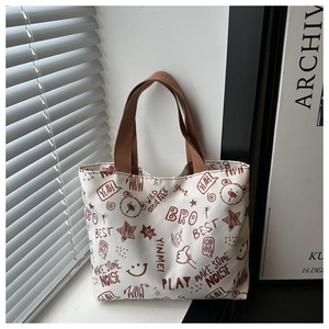 Détail du sac cabas en toile blanche avec motifs graffiti marron et anses tissées