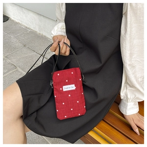 Close-up of red floral bucket bag with Creative Cat label and adjustable strap