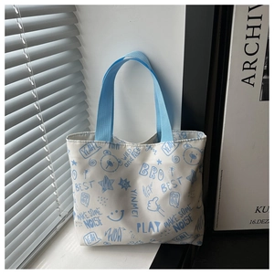 Détail d'un sac cabas en toile avec imprimés d'ours bleus et lettrage style graffiti