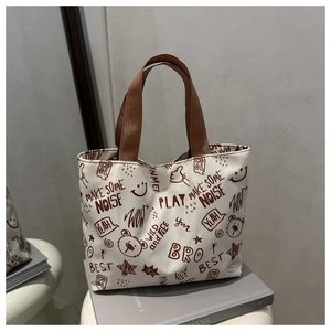 Détail du sac cabas en toile avec imprimés d'ours mignons et poignées en sangle marron