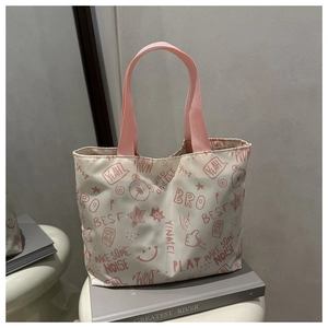 Détail d'imprimés graffitis roses sur un grand sac à bandoulière blanc cassé pour femme