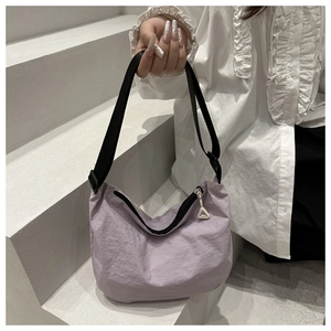 Detail view of lavender purple nylon pleated bag with black adjustable shoulder strap