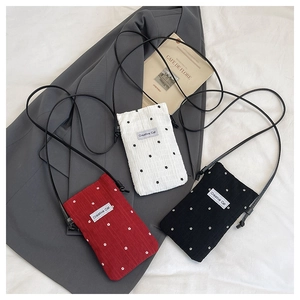 Detailed close-up of three mini floral crossbody bags in red, white and black colors