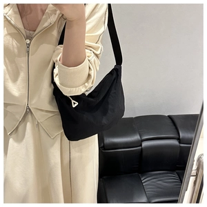 Minimalist black waterproof nylon crossbody bag with unique white triangular zipper detail