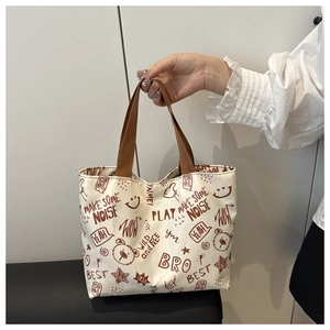 Détail d'un grand sac cabas en toile avec imprimés de dessins animés et anses tissées
