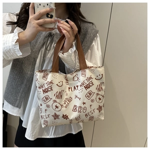 Détail du grand sac cabas blanc en toile avec des graffitis d'ours brun et des textes