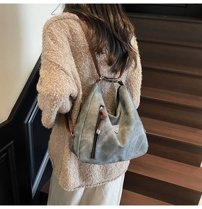Detail of vintage grey hobo bag with matte texture and decorative brown leather puller