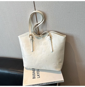 Close-up of white embossed tote bag with butterfly patterns and adjustable straps