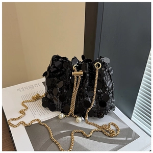 Détail du sac seau à paillettes noires avec chaîne dorée et perles sur le cordon