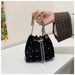 Detail of black drawstring bucket bag with rabbit print, metal chains and pearl charms