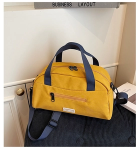 Detail view of bright yellow nylon tote bag with navy straps and JL Fashion label