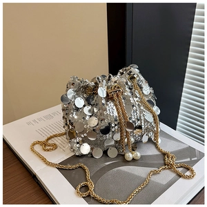 Détail du sac seau à paillettes argentées avec chaîne dorée et détails de perles de luxe