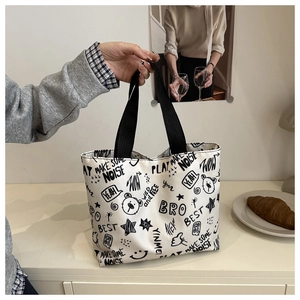 Détail du sac cabas en toile blanche avec graffiti de dessin animé noir et lanières