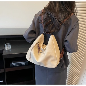 Detail of beige faux suede hobo bag with FASHION logo and brown leather strap