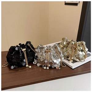 Détail de sacs seaux à paillettes noir, argent et or avec breloques en perles