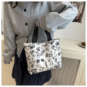 Détail du sac fourre-tout blanc en toile avec imprimé ours graffiti noir et anses noires