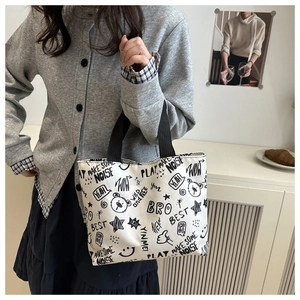 Détail d'un sac cabas en toile avec imprimés graffitis mignons et poignées en sangle noires