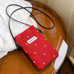 Red pleated bucket bag with small daisy floral patterns and creative cat label