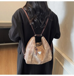 Detail of vintage brown tote bag featuring knotted zipper and silver triangle hardware
