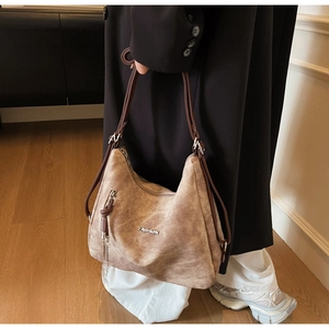 Detail of vintage brown tote bag with decorative zippers and fashion metal logo
