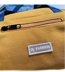 Detail of yellow ripstop nylon bag showing JL FASHION logo and high-quality zipper texture