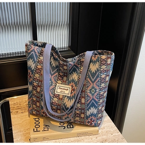 Detailed shot of ethnic woven tote bag with colorful geometric patterns and blue handles