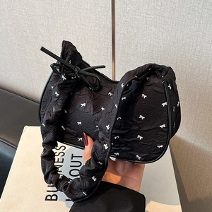 Chic black ballet style shoulder bag featuring white bow patterns and pleated textures