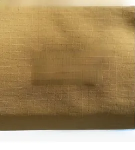 Close-up of the JL FASHION rubber patch on yellow checkered crossbody pillow bag