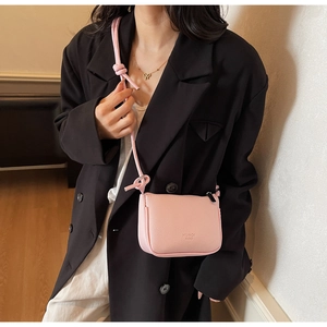 Pink lychee texture mini crossbody bag shown on a black suit for a stylish daily look