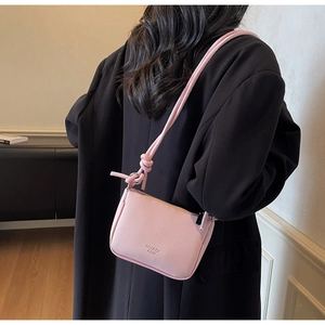 Detailed view of pink lychee texture leather mini crossbody bag with knot strap detail