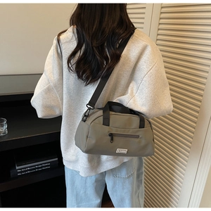 Detail of olive green nylon crossbody bag with JL FASHION logo and black shoulder strap