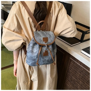 Détails du sac à dos vintage en toile bleu-gris avec finitions en cuir brun et cordon