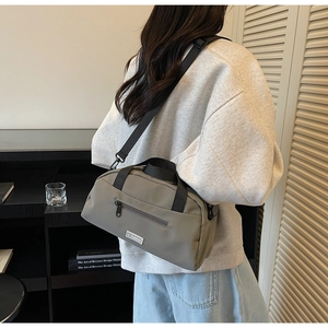 Detail of olive gray nylon tote bag with JL FASHION label and crossbody strap