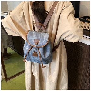 Vue détaillée d'un sac à dos en toile vintage avec des lanières en cuir marron