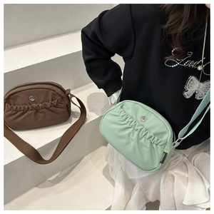 Dettaglio delle borse a tracolla in nylon arricciato marrone e verde menta con logo M