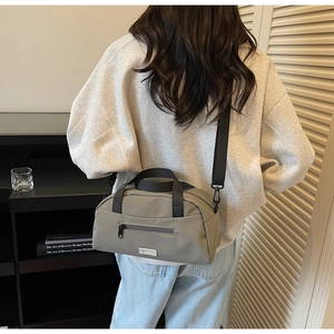 Detail of grey nylon crossbody bag with detachable strap and JL FASHION logo tag