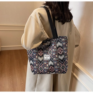Close-up of ethnic patterned tote bag with woven geometric designs and fabric shoulder strap