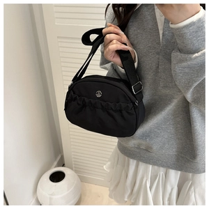 Dettaglio borsa a tracolla in nylon nero a pieghe con logo M in metallo e tracolla