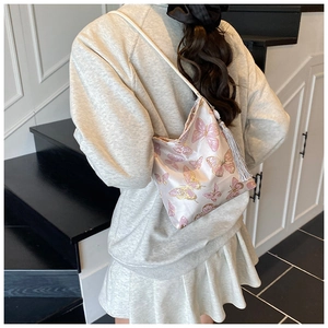 Fashionable bucket bag with butterfly embroidery and long tassel detail worn by model
