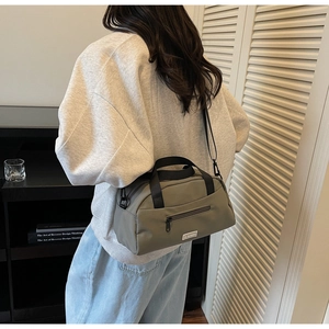 Detailed back view of a minimalist army green nylon crossbody tote bag worn by a model
