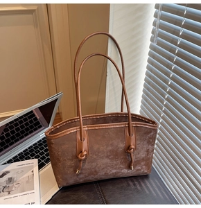 Detail of vintage brown leather tote bag with metallic ring and soft matte texture