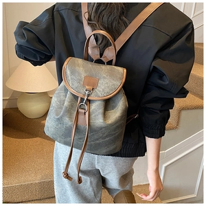 Vue arrière d'un sac à dos vintage gris avec finitions en cuir marron sur un mannequin